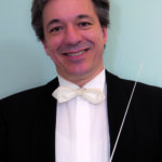 Lächelnder Dirigent im Anzug mit Taktstock