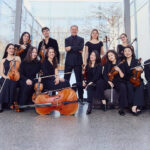 Orchestergruppe mit Streichinstrumenten in modernem Gebäude