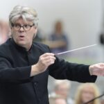 Dirigent leitet ein Orchester mit Taktstock