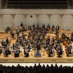 Symphonieorchester spielt auf Konzertbühne vor Publikum