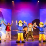 Bühnenaufführung mit Feuerwehrfiguren und Kindern